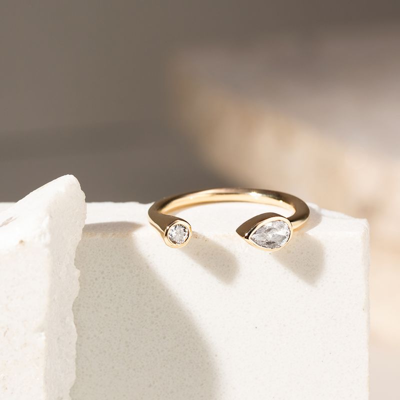 Anel-Aro-Aberto-com-Zirconias-Brancas-Gota-e-Redonda---Banho-de-Ouro-18k
